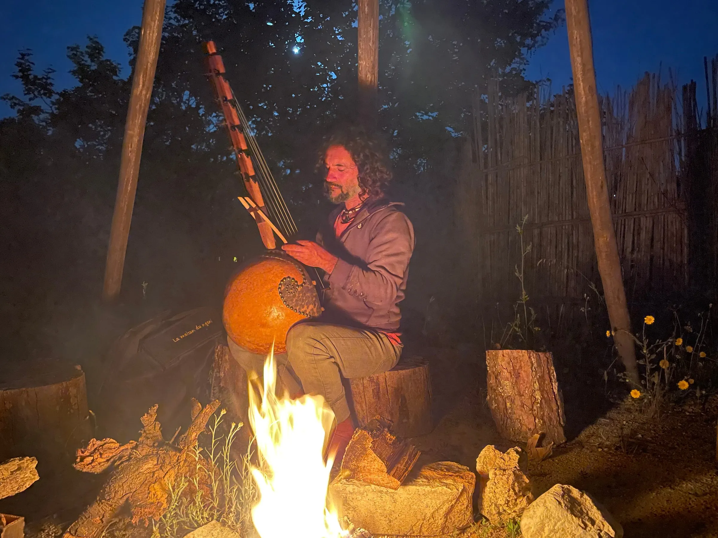 Peppi playing the kora by a fire at night