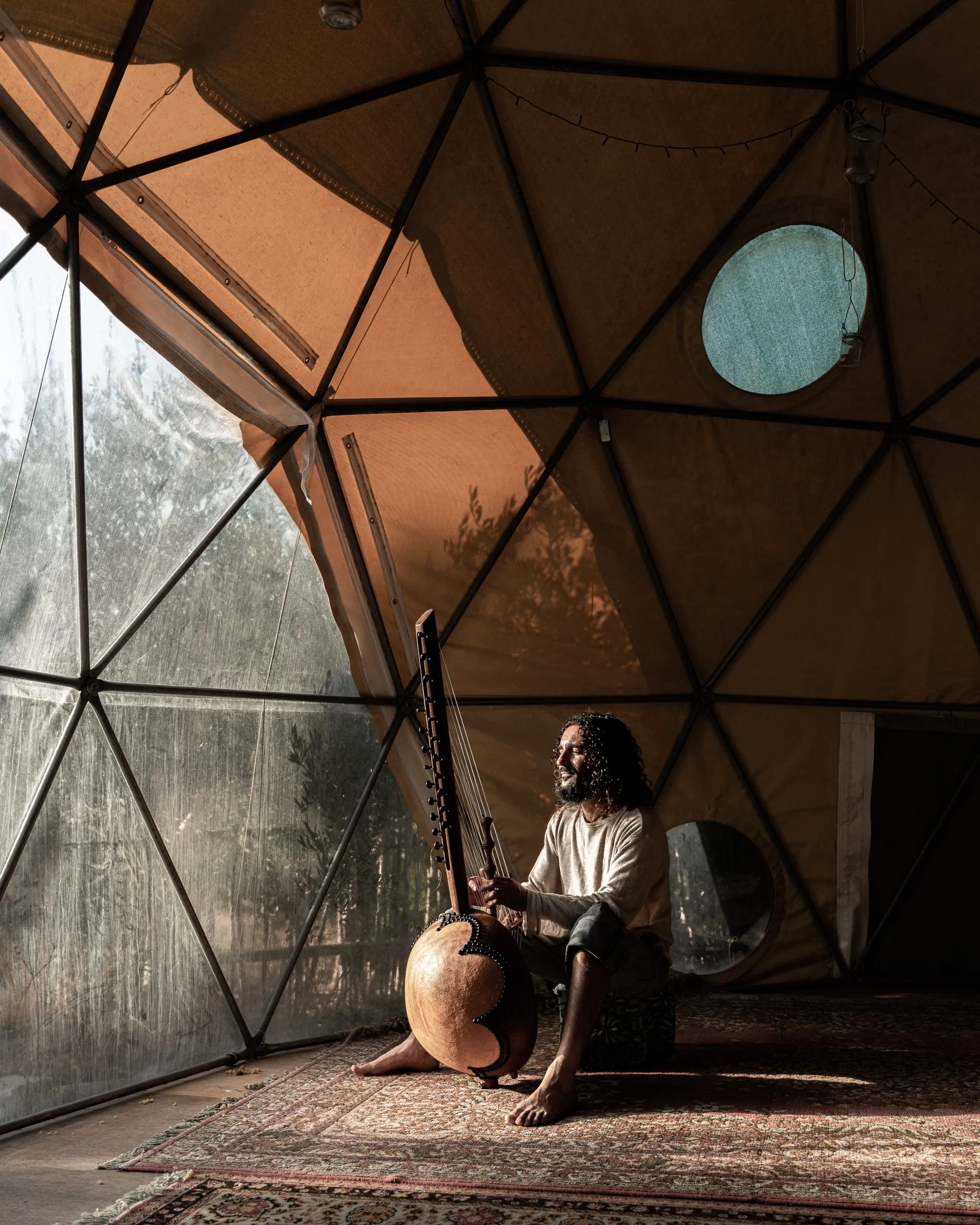 Peppi playing the kora inside a geodesic dome